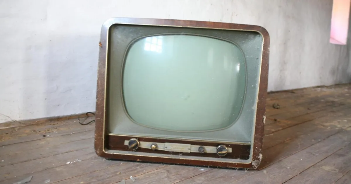 An individual attempting to troubleshoot a television that is not turning on, exploring remote and power cord options.